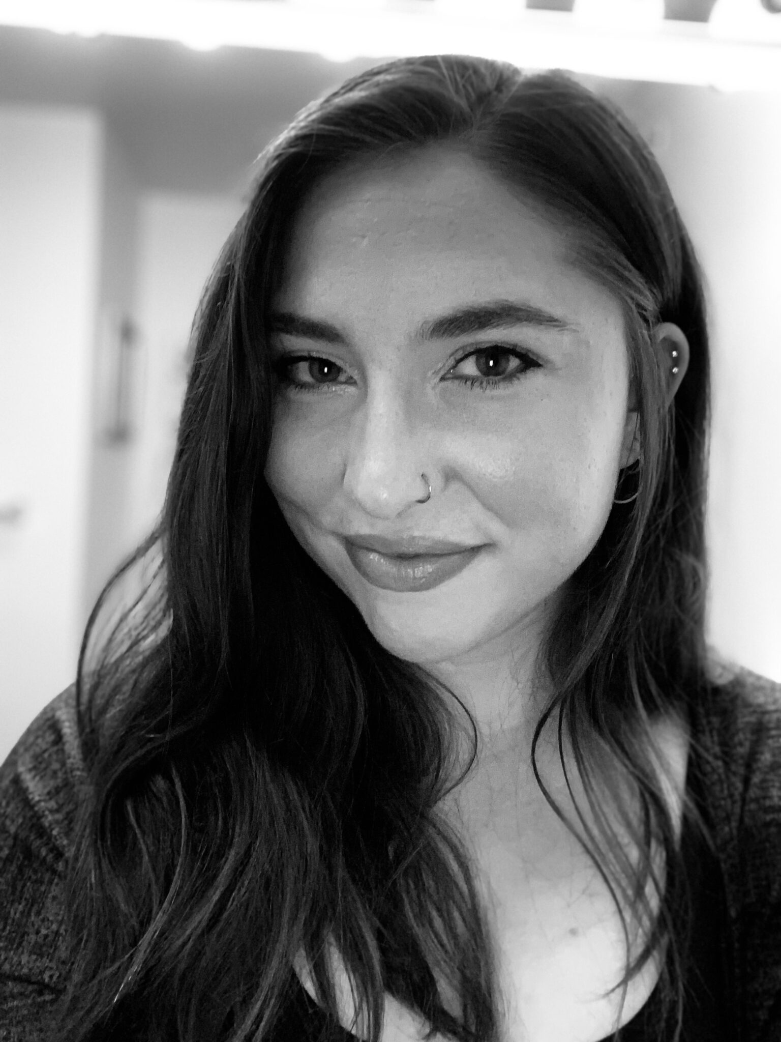 Black and white portrait of a smiling woman with long hair.