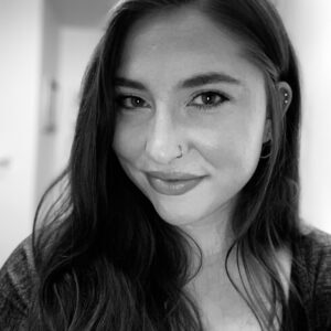 Black and white portrait of a smiling woman with long hair.