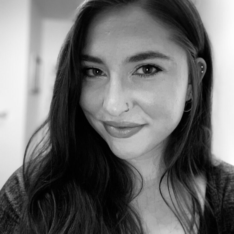 Black and white portrait of a smiling woman with long hair.